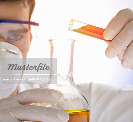 Close up of scientist pouring liquid from test tube