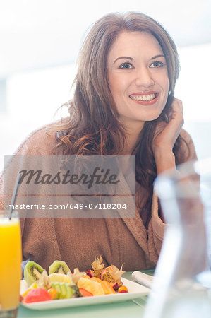 Woman at hotel poolside with fresh fruit and orange juice