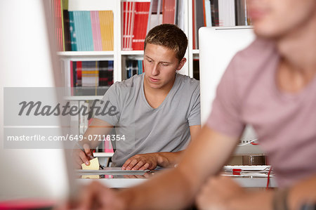 Young men working, focus on background
