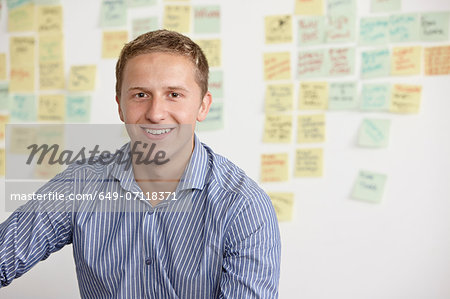 Portrait of young man with adhesive notes in background