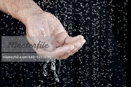 Hand catching water droplets