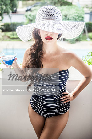 Young woman holding blue cocktail