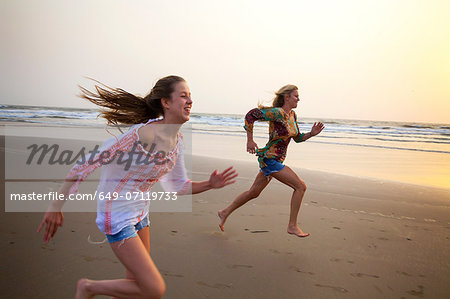 Mother and daughter running on beach Mother and daughter running on beach
