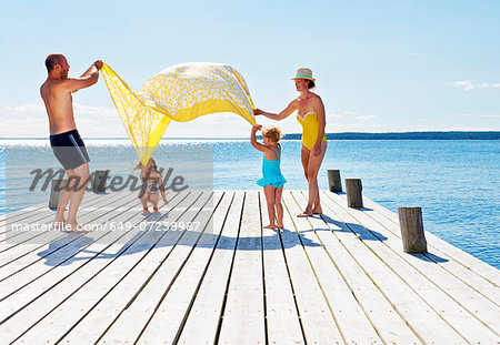 Parents and two young girls playing on pier, Utvalnas, Gavle, Sweden