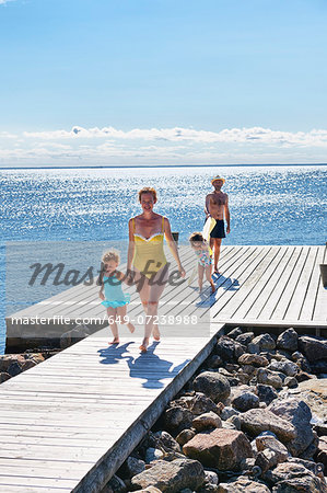 Parents and two young girls on pier, Utvalnas, Gavle, Sweden Parents and two young girls on pier, Utvalnas, Gavle, Sweden