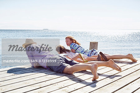 Family lying on pier, Utvalnas, Gavle, Sweden Family lying on pier, Utvalnas, Gavle, Sweden