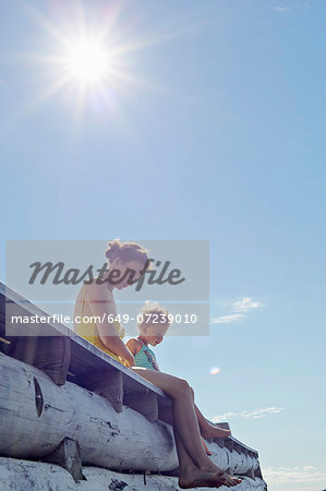 Mother and daughter sitting on pier, Utvalnas, Gavle, Sweden