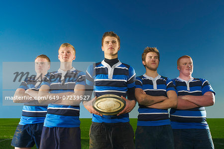 Portrait of rugby team, one man holding ball