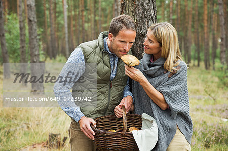 Mid adult couple foraging for mushrooms in forest