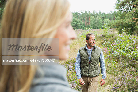 Mid adult man looking away, woman blurred in foreground