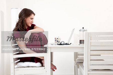 Young woman sitting at table with laptop