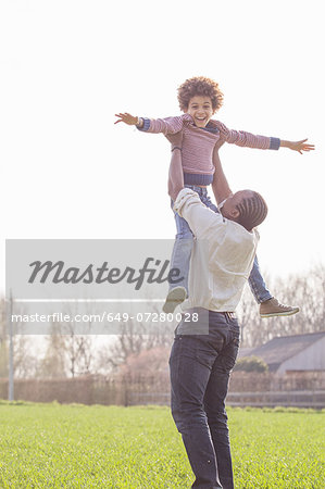 649-07280028em-Father-lifting-up-son-in-field.jpg