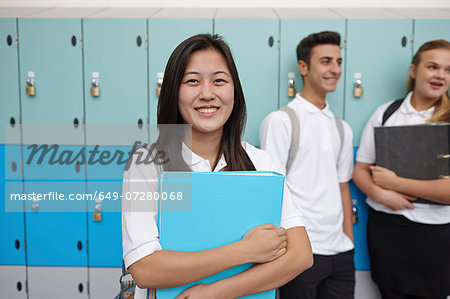 Portrait of teenage schoolgirl next to lockers