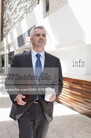 Businessman walking down corridor in office