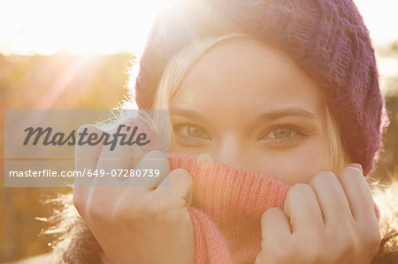 Portrait of young woman wearing knit hat, mouth covered