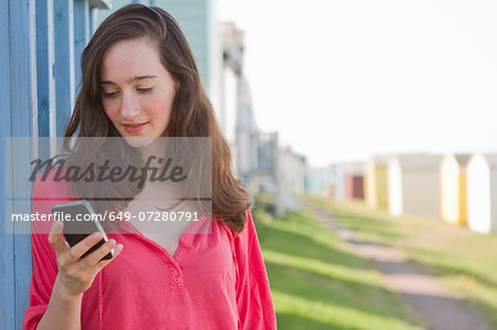 Portrait of young woman with mobile phone, Whitstable, Kent, UK