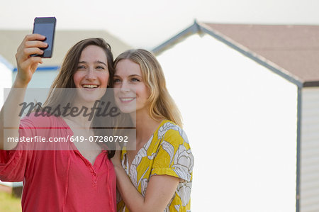Two young female friends taking self portrait, Whitstable, Kent, UK