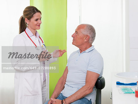 Female doctor talking to senior male patient