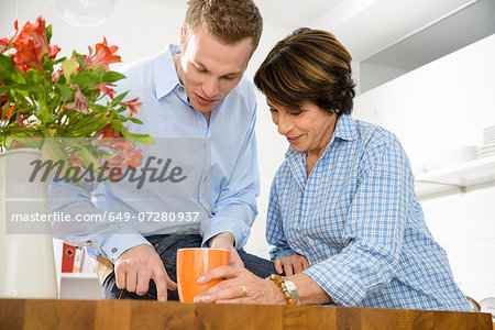 Adult grandson and grandmother in kitchen