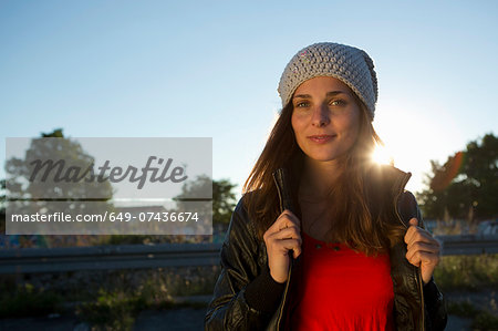 Portrait of young woman in leather jacket and beanie