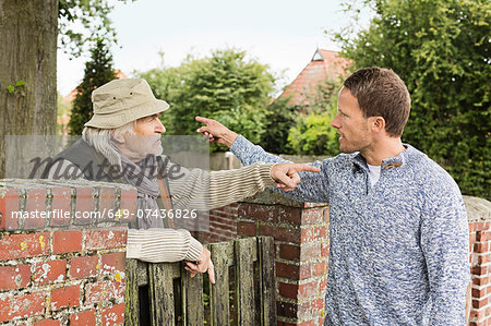 Senior man and mid adult man arguing