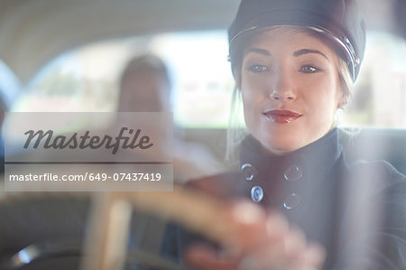 Woman playing chauffeur in vintage car