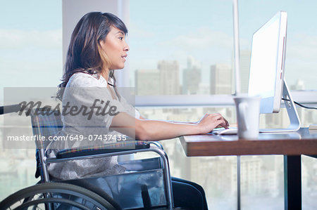 Woman in wheelchair using computer