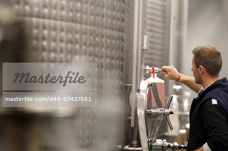 Man working in industrial wine cellar Man working in industrial wine cellar