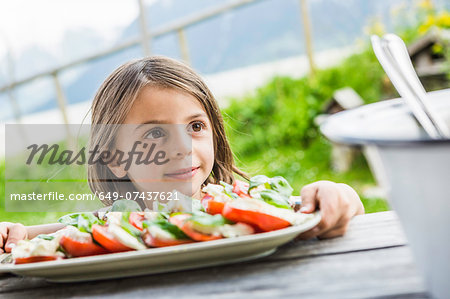 Young girl holding salad plate for picnic lunch, Tyrol, Austria