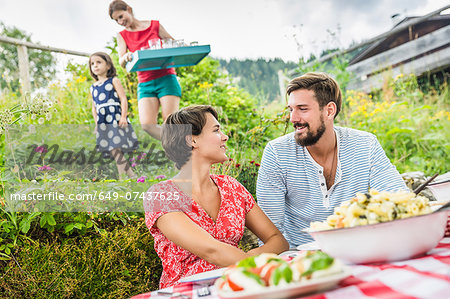 Young couple sharing picnic lunch, Tyrol, Austria Young couple sharing picnic lunch, Tyrol, Austria