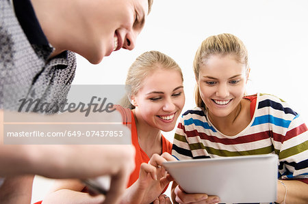Three young adult friends with digital tablet