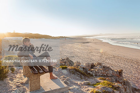 Man relaxing on beach bench