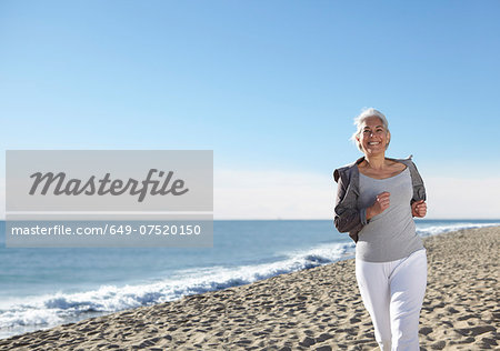 Mature woman jogging on beach