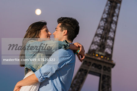 Young couple embracing in moonlight, Paris, France