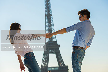 Young couple in front of  Eiffel Tower, Paris, France