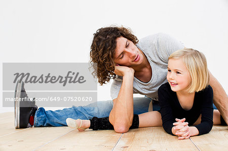 Studio shot of father posing with ballerina daughter