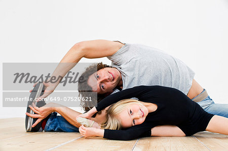 Studio shot of father and ballerina daughter doing splits