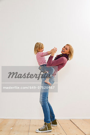 Studio portrait of mother playing with young daughter