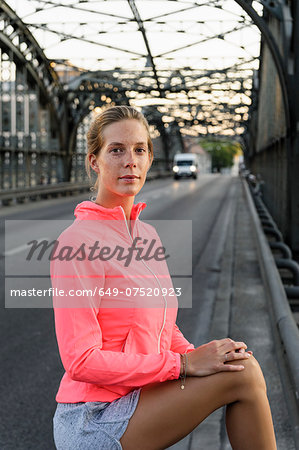 Portrait of young female runner on bridge