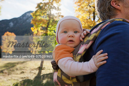 Father carrying baby daughter in carrier