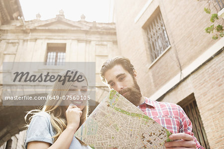 Young tourist couple looking at map outside Valencia Cathedral, Valencia, Spain