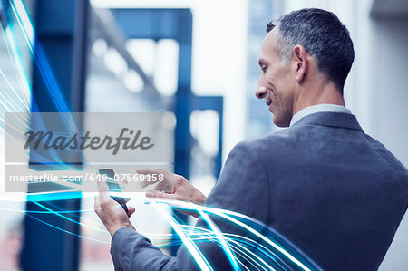 Waves of blue light and businessman using touchscreen on smartphone Waves of blue light and businessman using touchscreen on smartphone