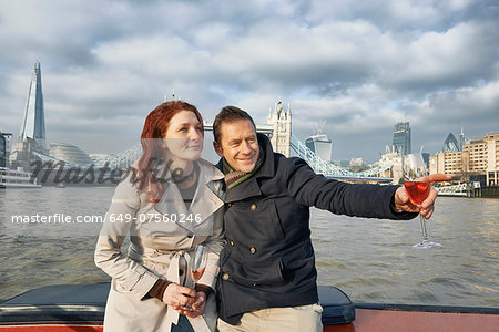 Romantic couple on Thames boat with pink champagne, London, UK