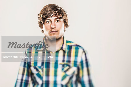 Studio portrait of young man in checked shirt