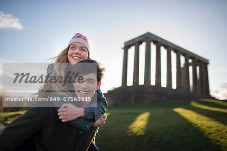 A young couple on Calton Hill with the background of the National Monument of Scotland in Edinburgh