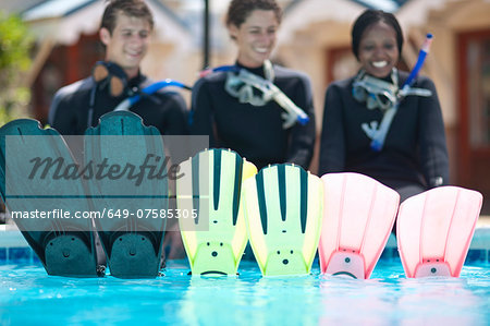 Portrait three young adult scuba divers and their flippers