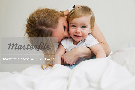 Portrait of mid adult woman hugging her year old baby girl