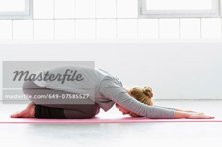 Young woman in yoga pose on yoga mat