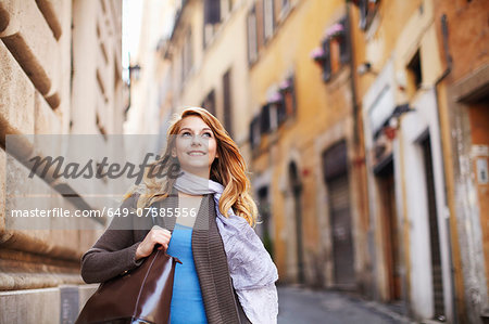 Young woman strolling down street, Rome, Italy