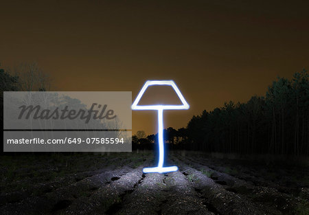 Field landscape at night with light painted drawing of lamp